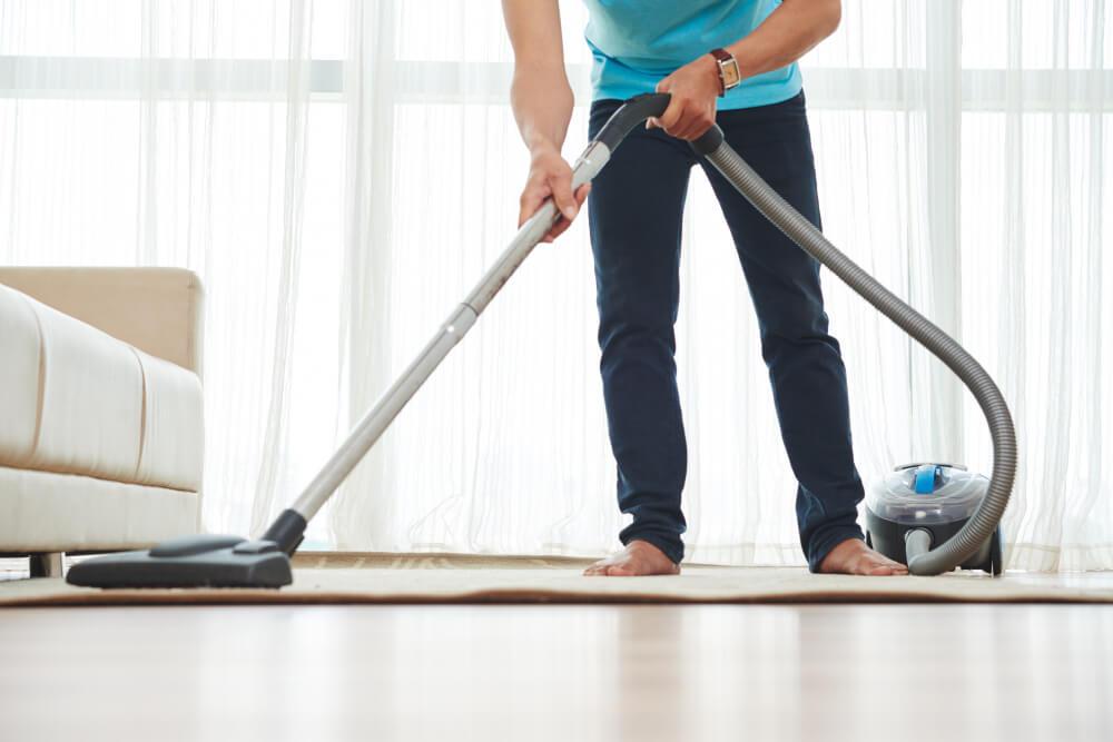 a man vacuuming the carpet